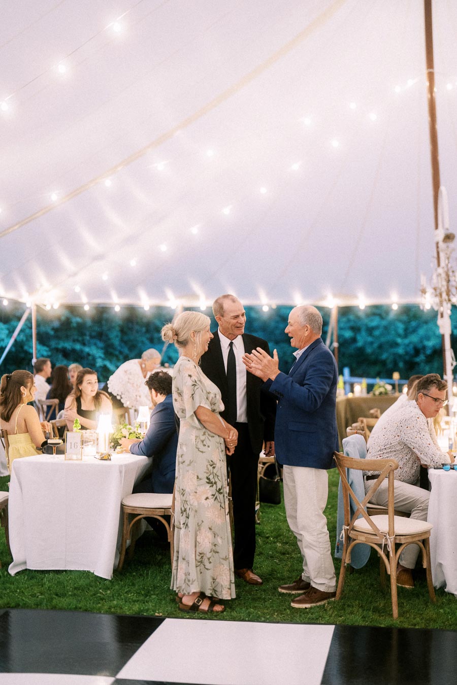 Guests talking during an outdoor tented wedding reception on a private farm estate near Chatham-Kent, Ontario, Canada.