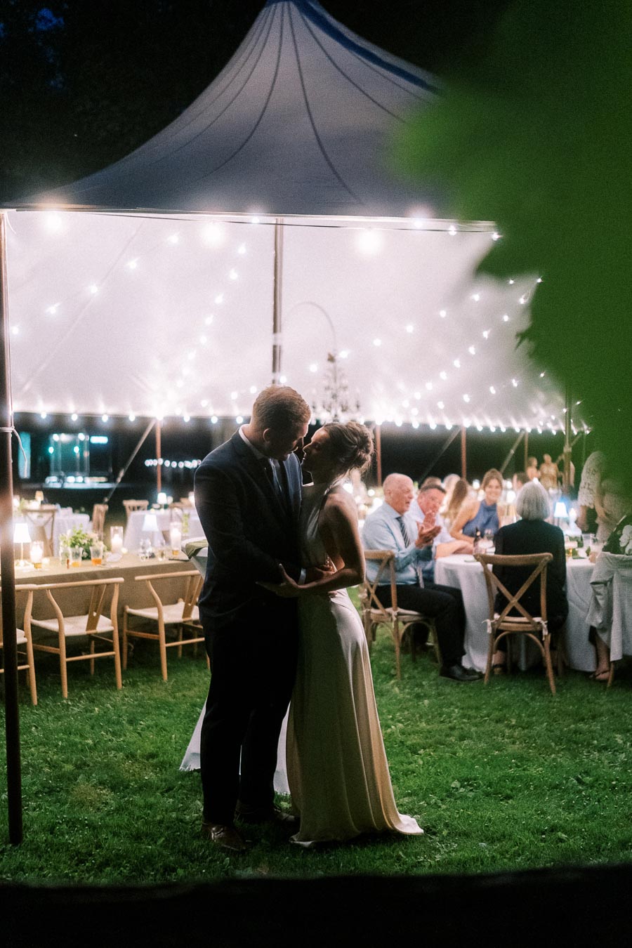 Bride and groom dancing under a lit wedding tent during an outdoor reception in Chatham-Kent, Ontario, Canada.