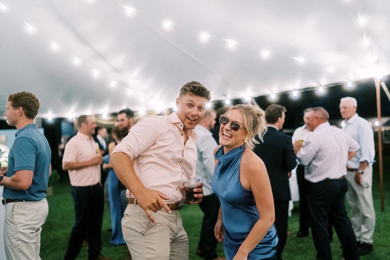 Guests smiling and dancing during an outdoor tented wedding reception on a private farm estate near Chatham-Kent, Ontario, Canada.