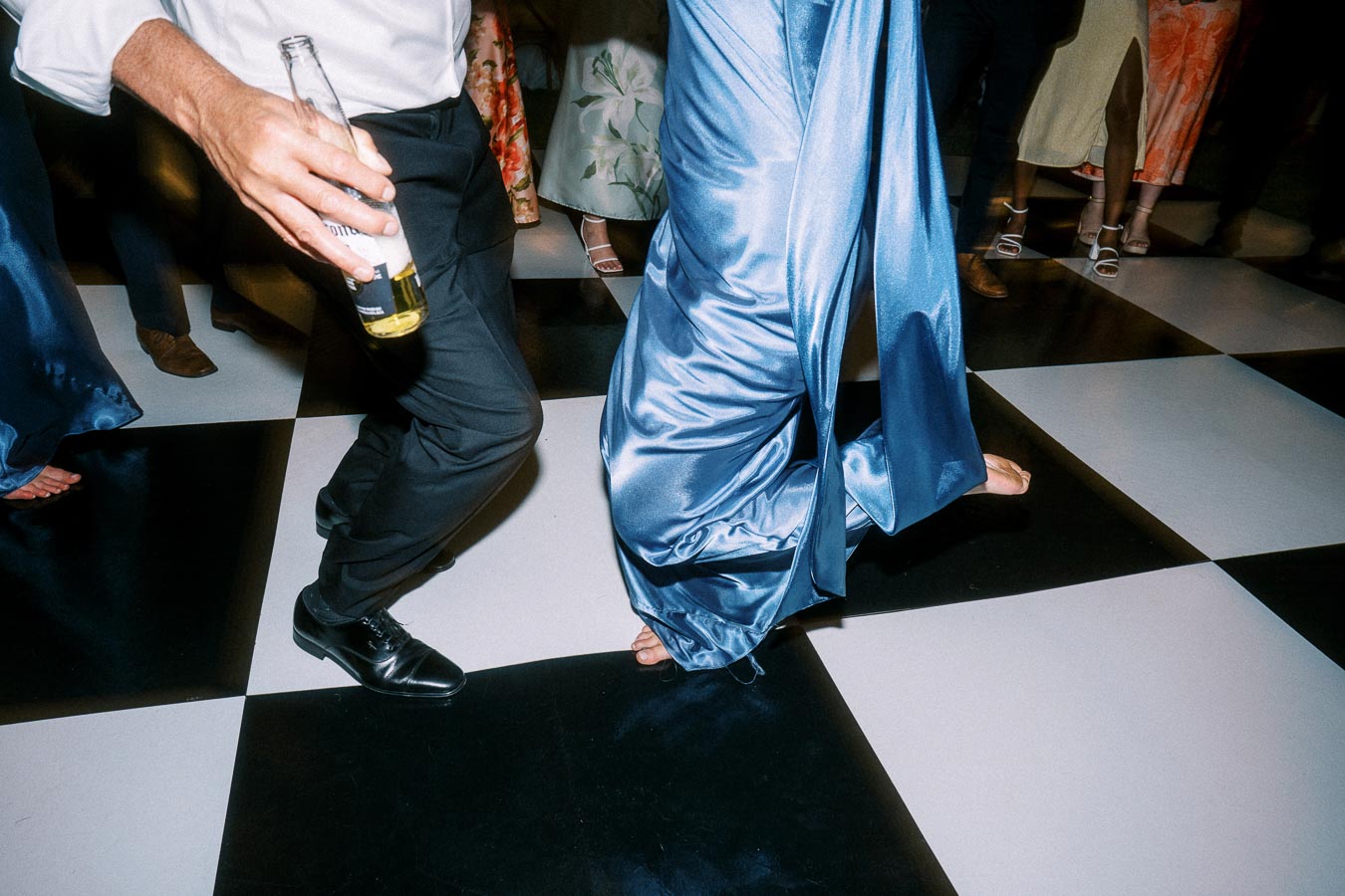 Wedding guests dancing on a black and white checkered dance floor during a tented private estate reception near Chatham-Kent, Ontario.