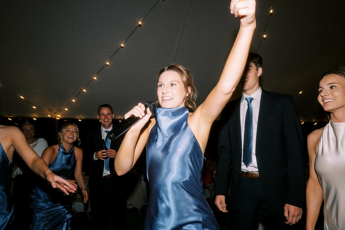 Wedding guests celebrating under a tent with string lights at a private estate farm wedding near Chatham-Kent, Ontario, Canada.
