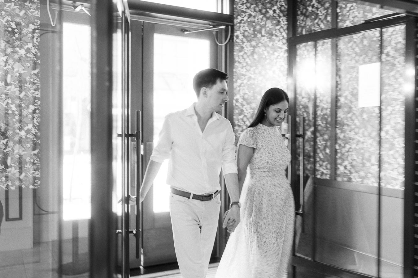 Mike and Becky holding hands inside a bright doorway with floral walls