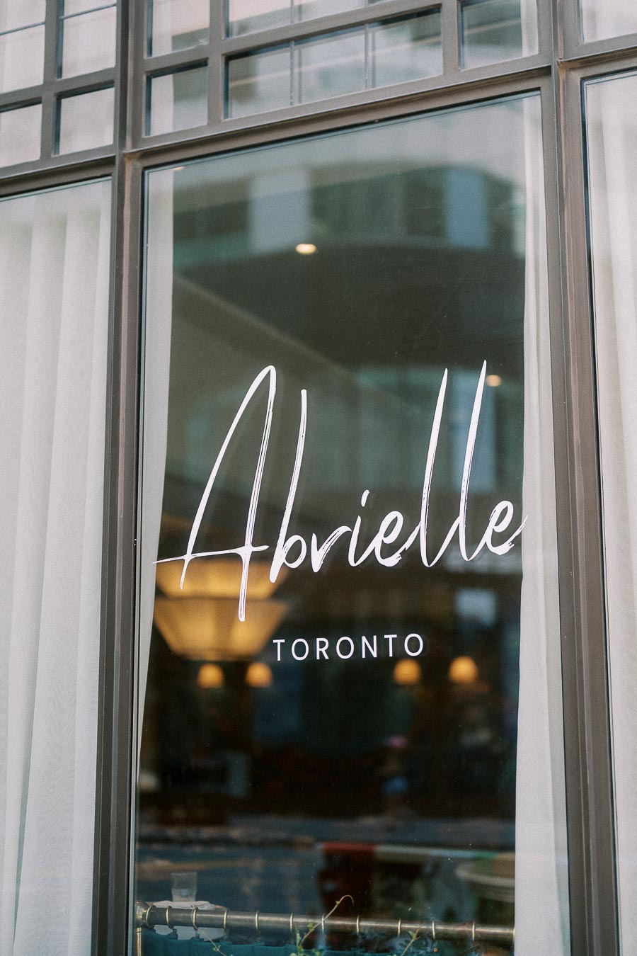 Abrielle Toronto script logo on a tall glass window