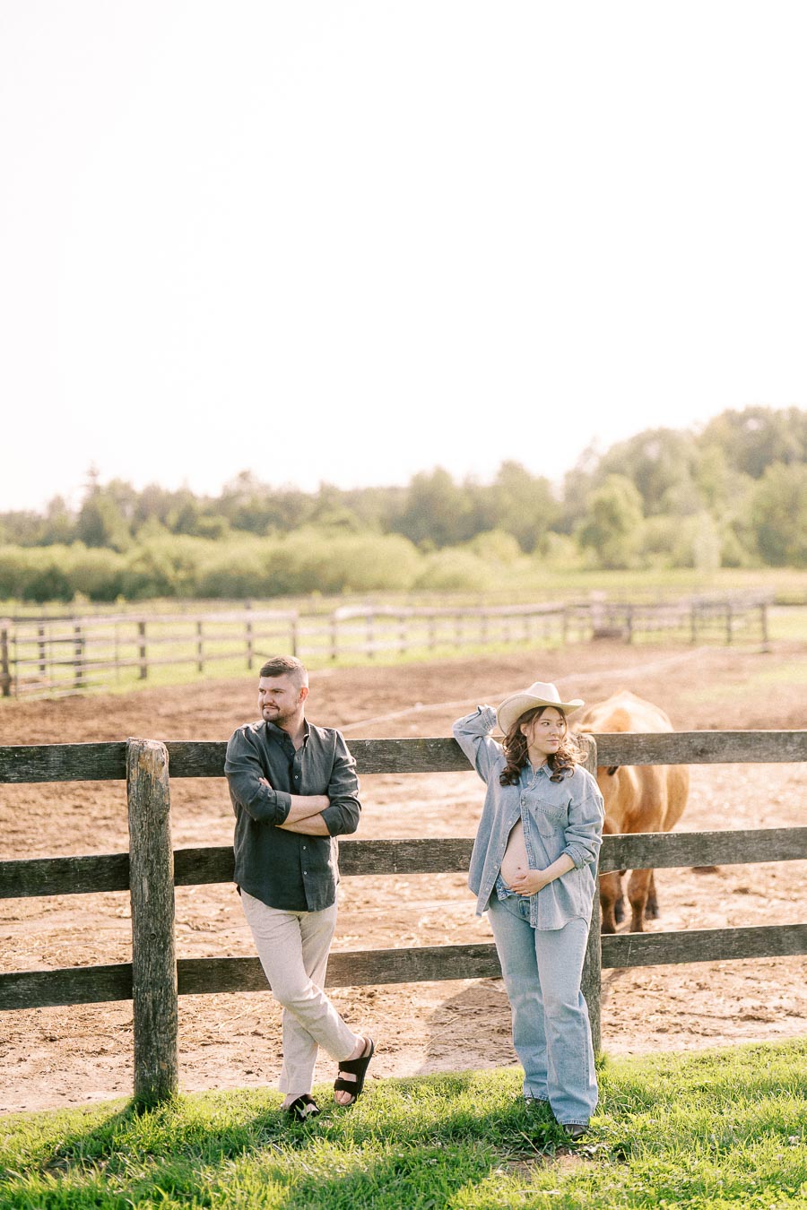 Maternity couple by a paddock fence with a horse at The Green Acres