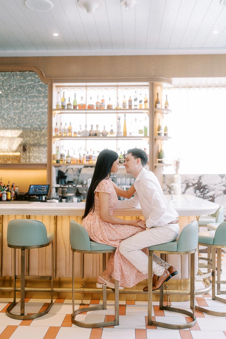 Couple seated on bar stools leaning close inside a bright Toronto restaurant