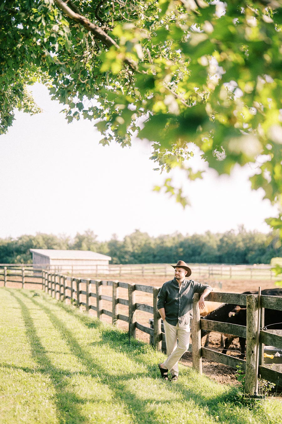 Man in hat leaning on fenced pasture at The Green Acres in Flamborough