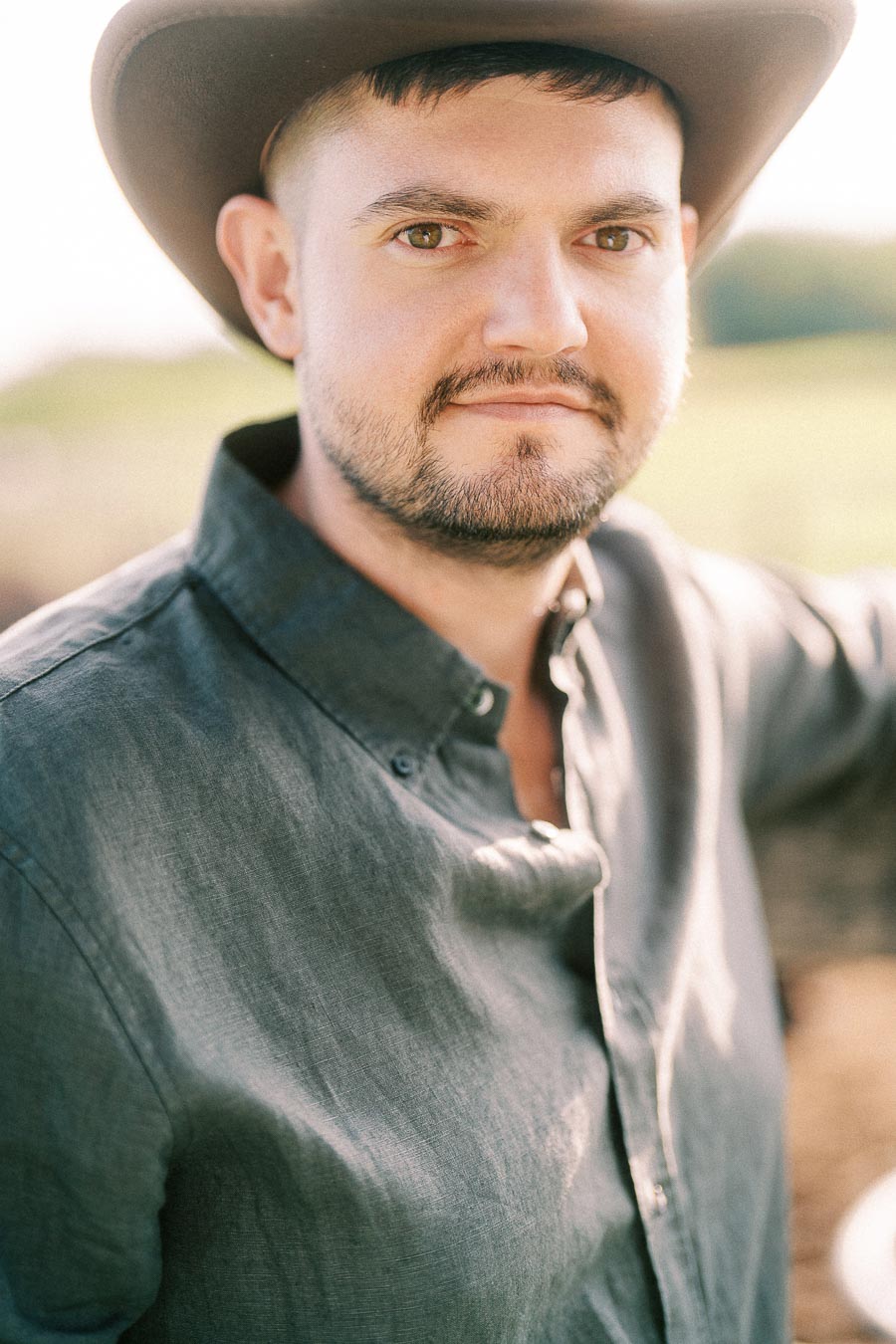 Man in a cowboy hat and green shirt outdoors at The Green Acres