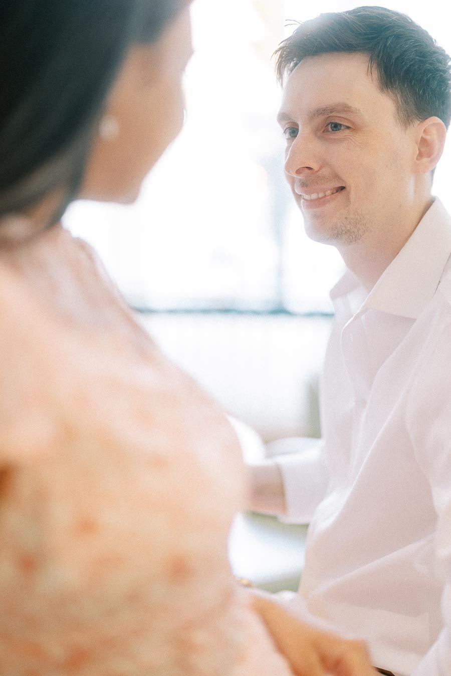 Man smiling at his fiancée during a soft indoor engagement portrait