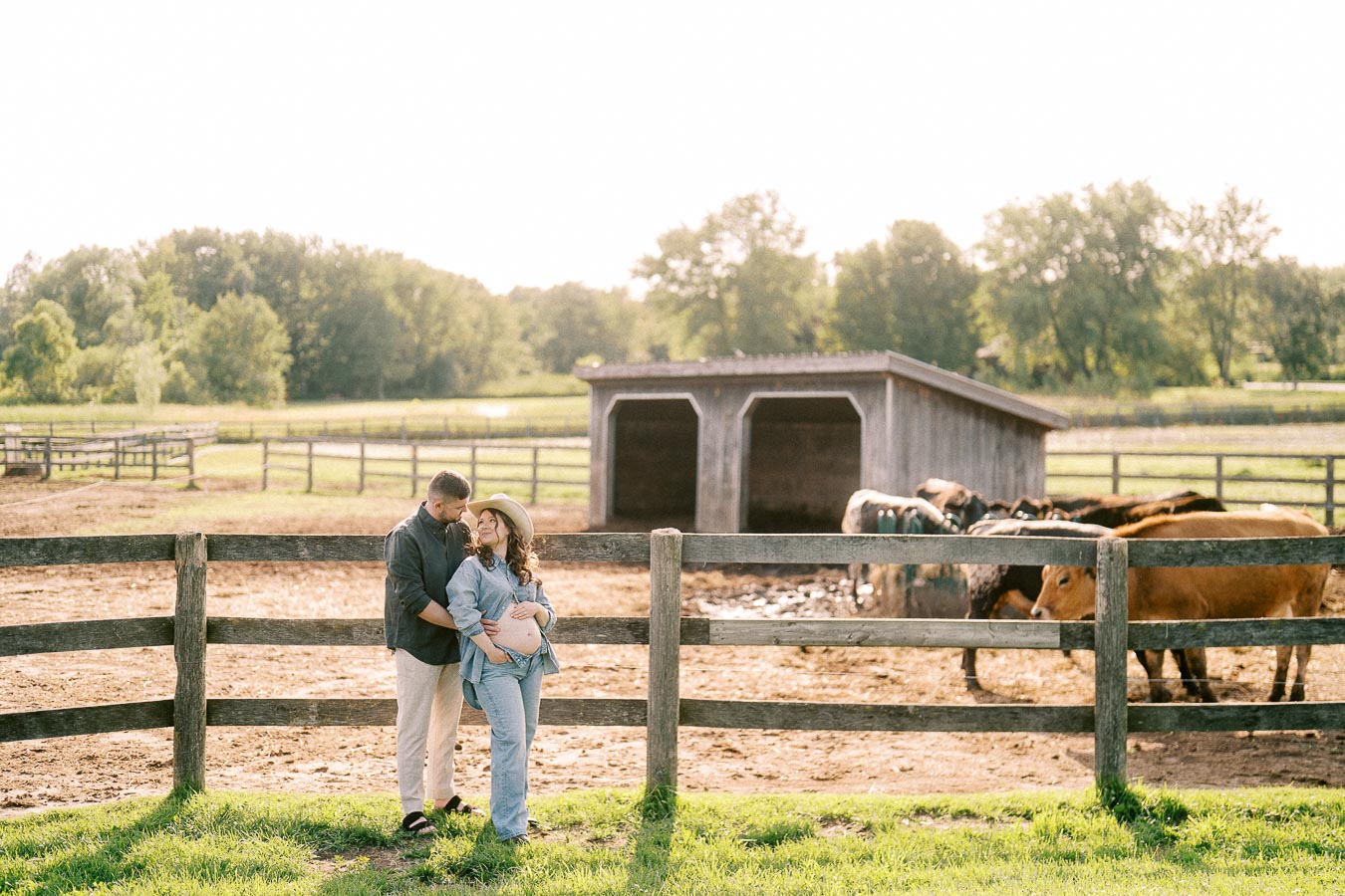 Expectant couple by a horse paddock at The Green Acres in Flamborough, Ontario