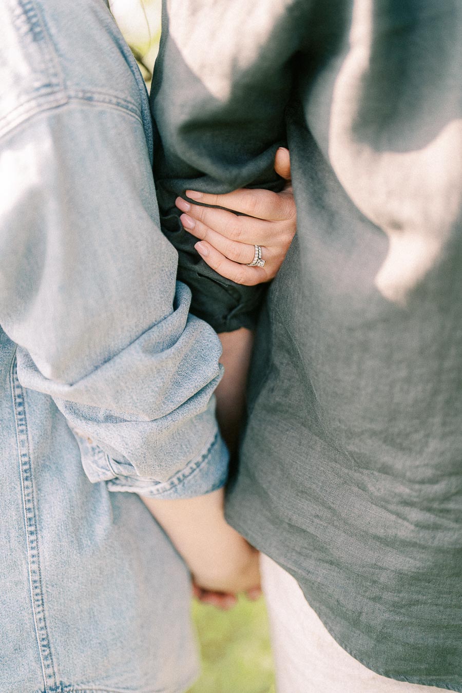 Close embrace with ringed hand during a maternity session
