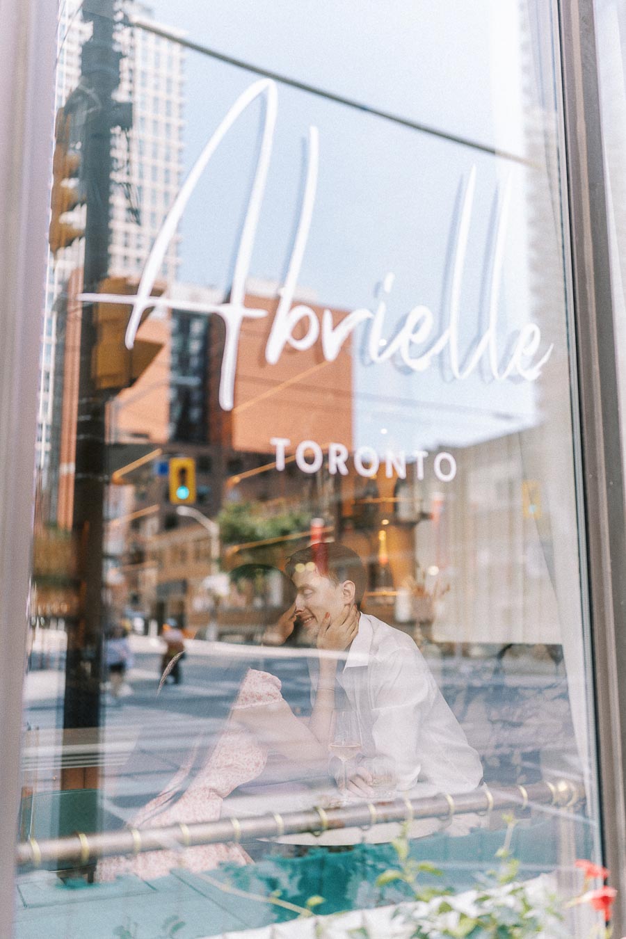 Couple reflected in Abrielle Toronto window during an engagement session