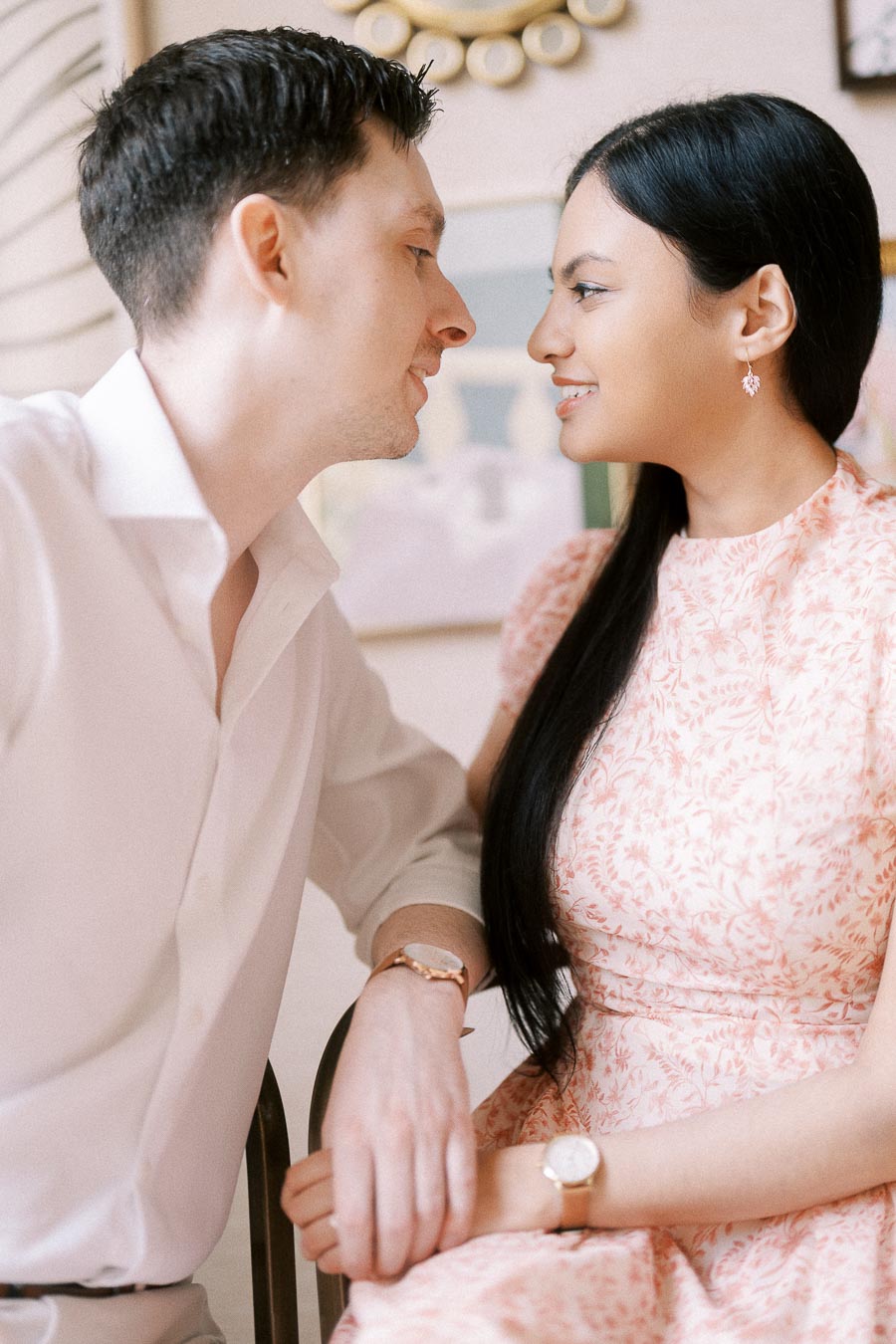 Mike and Becky smiling closely together indoors during their engagement session