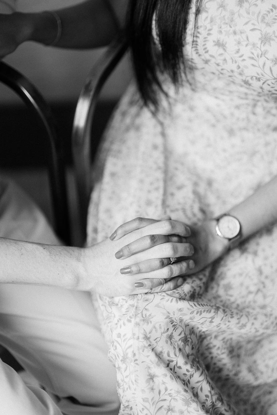 Black and white close-up of Mike and Becky holding hands indoors