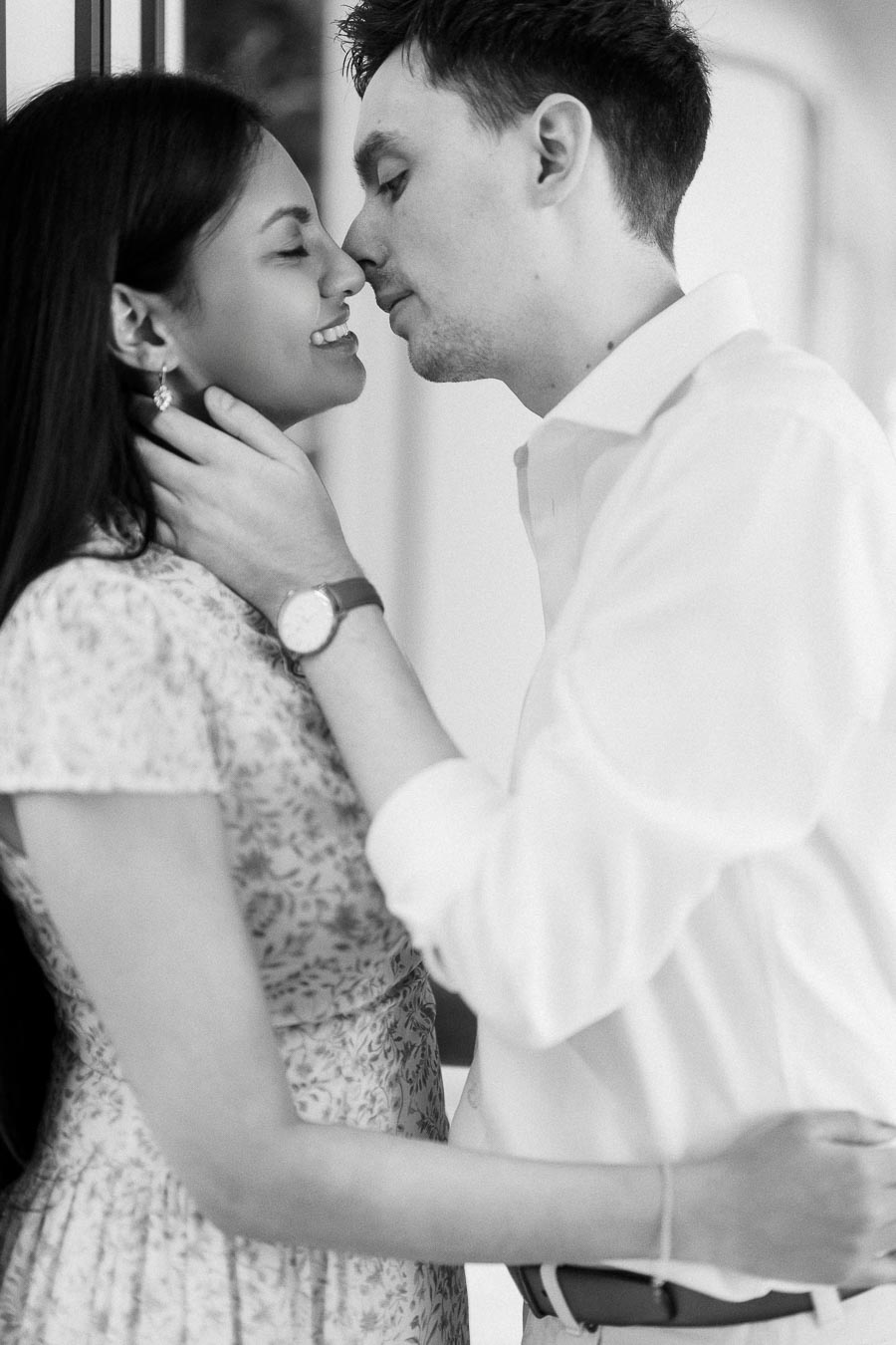 Black and white close-up of engaged couple sharing a tender near kiss