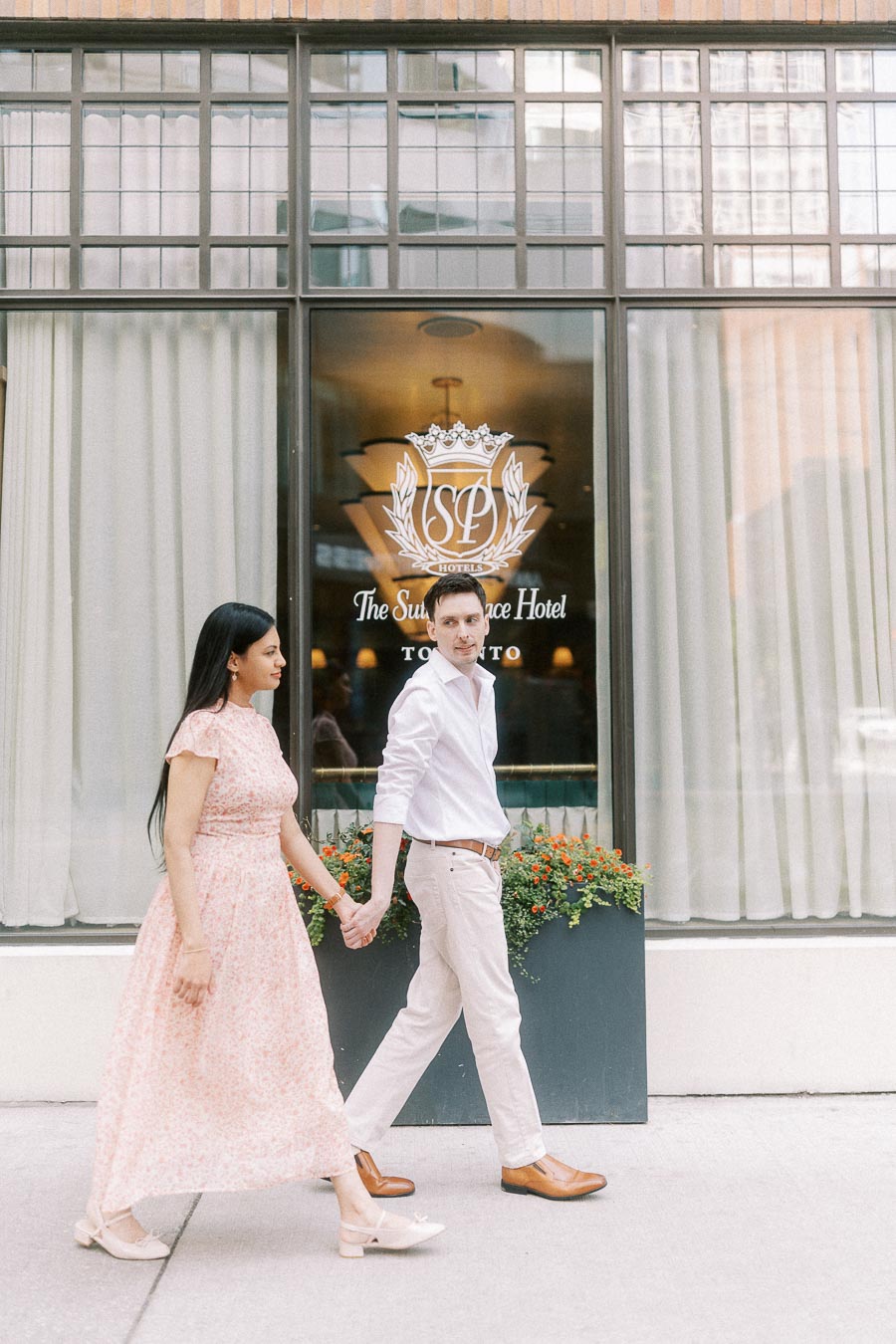 Couple holding hands outside The Sutton Place Hotel in Toronto