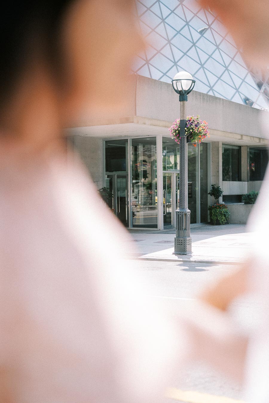 Soft-focus couple framing a downtown Toronto entrance and flower basket