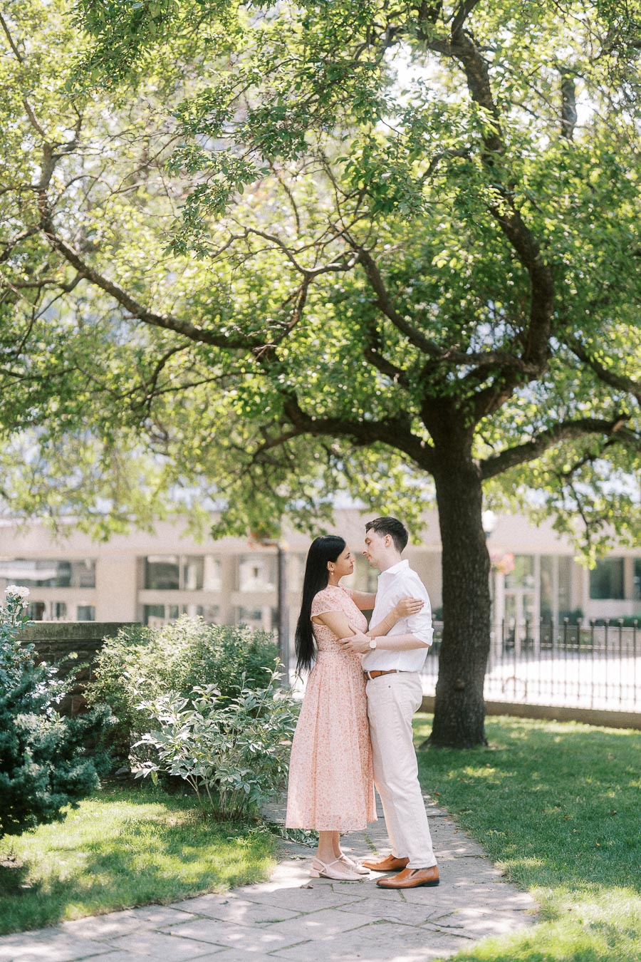 Couple standing together on a garden path beneath a leafy tree in Toronto