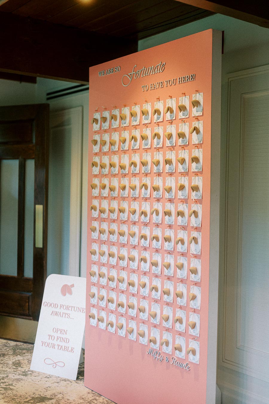 Pink fortune cookie seating chart display for Miffy and Rawle’s wedding reception.