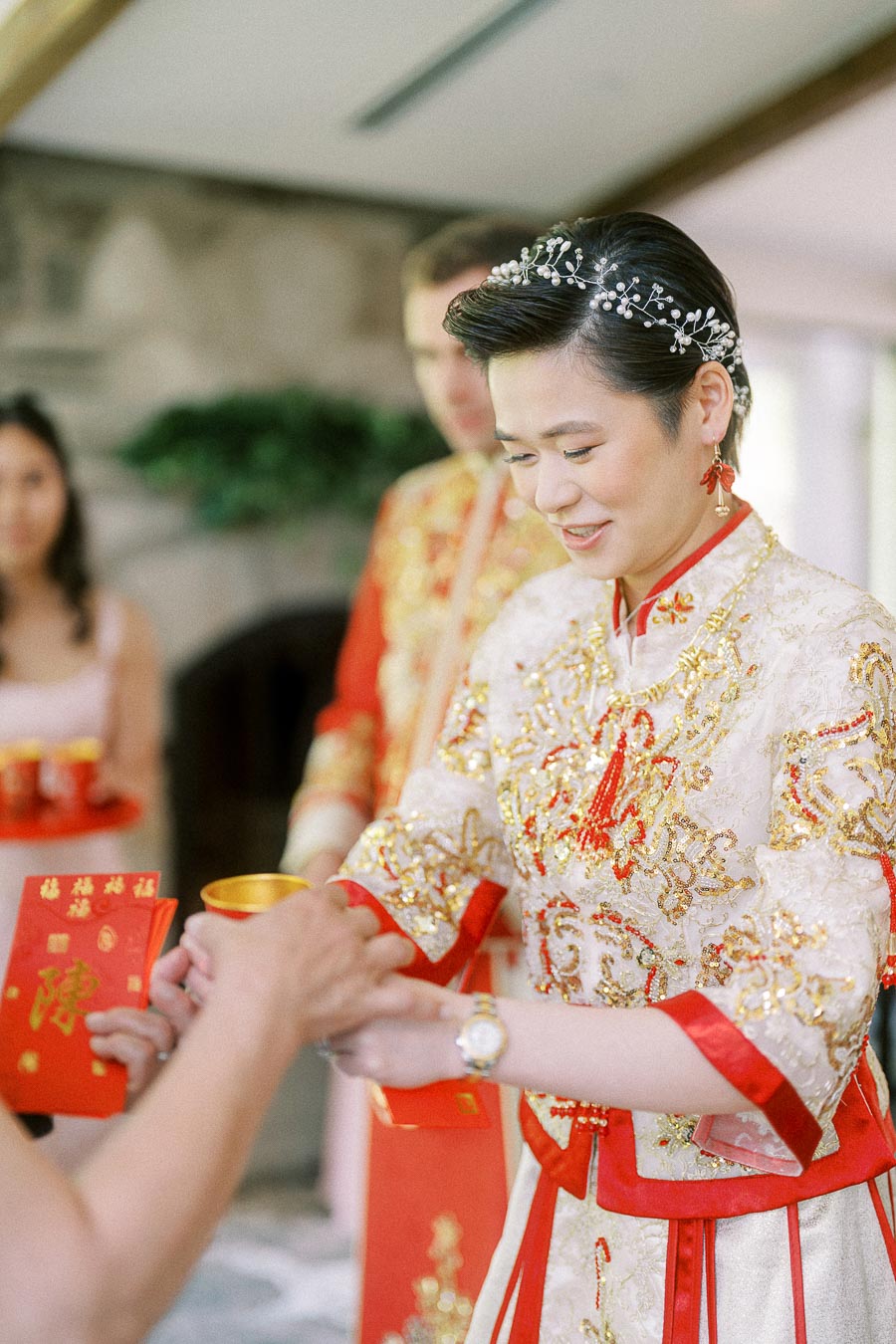 Miffy in an embroidered red and gold Chinese wedding outfit accepts a tea cup during a tea ceremony.