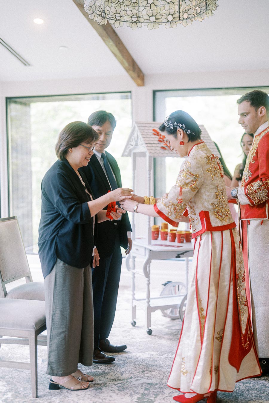 Miffy bows while offering tea to an elder during a Chinese tea ceremony indoors at Ancaster Mill.