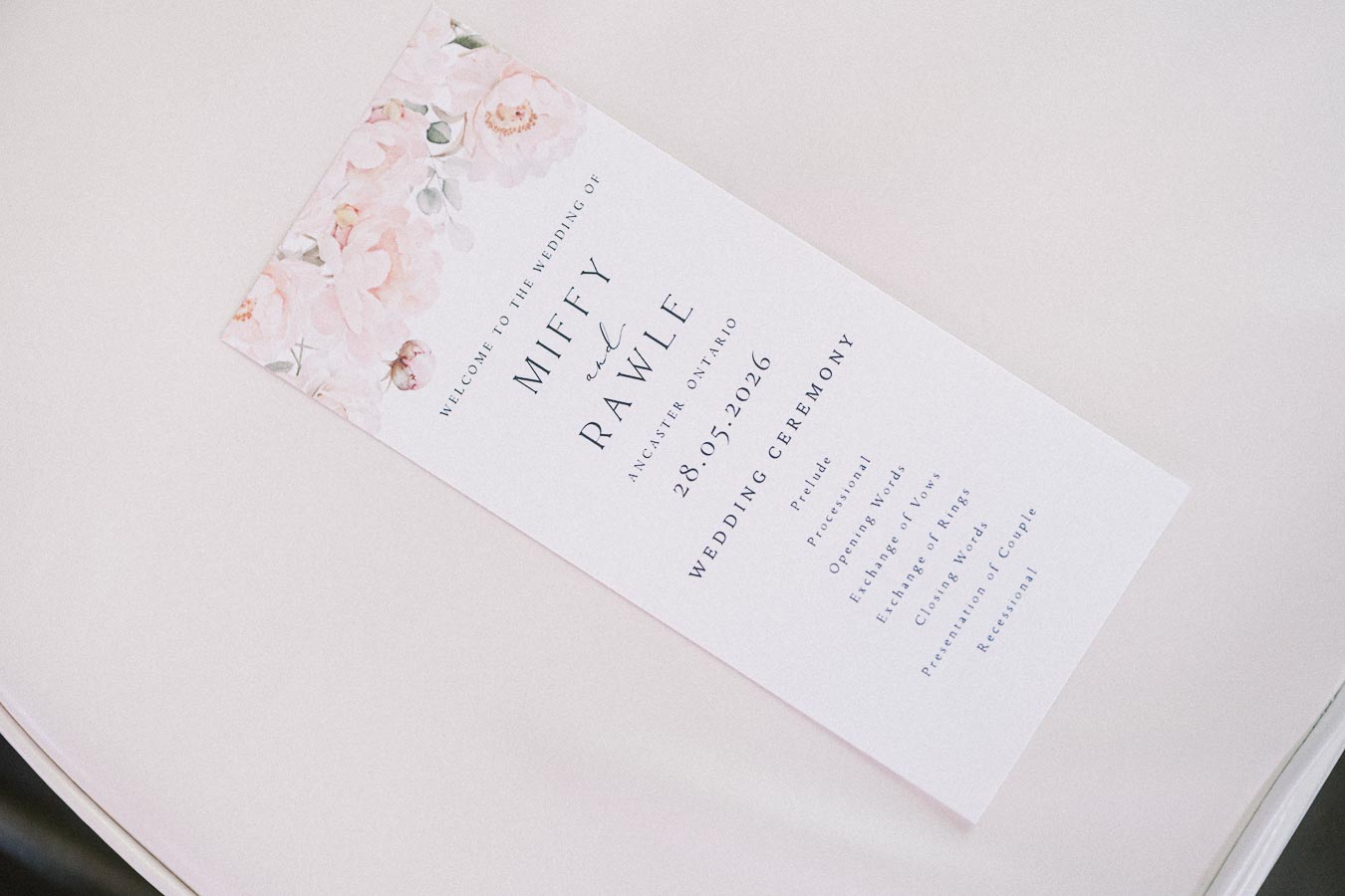 Floral wedding ceremony program for Miffy and Rawle dated May 28, 2026 at Ancaster Mill.