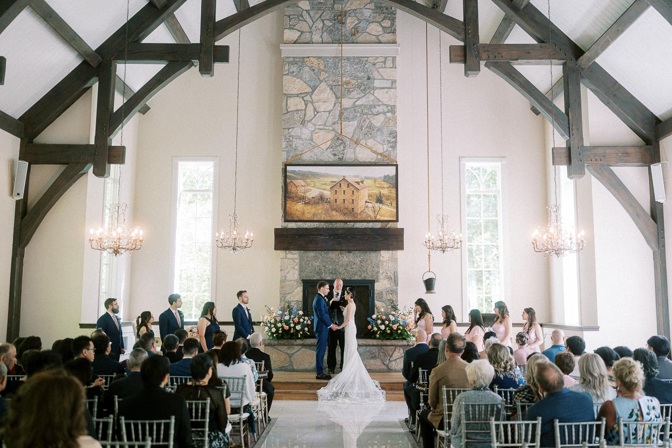 Miffy and Rawle stand at the altar during their chapel ceremony as guests watch inside Ancaster Mill.