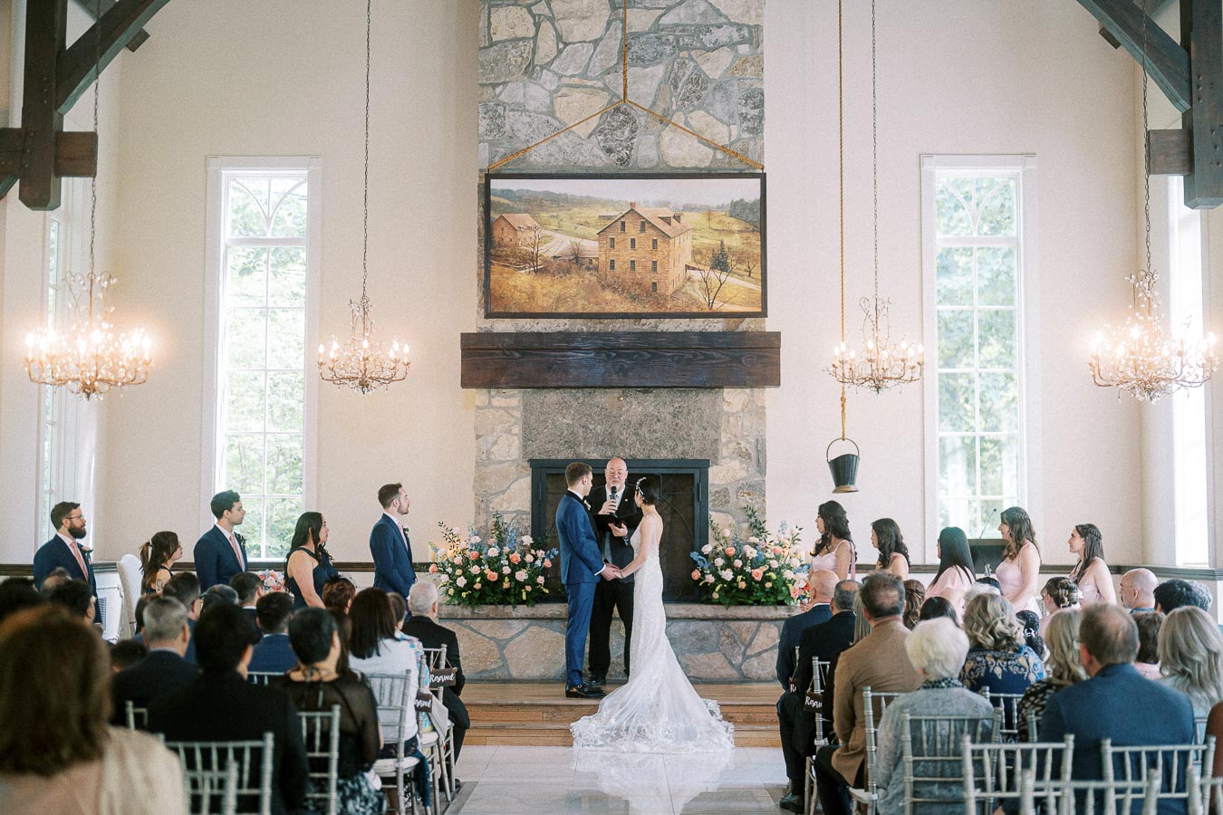 Bride and groom hold hands during their chapel ceremony before guests at Ancaster Mill.