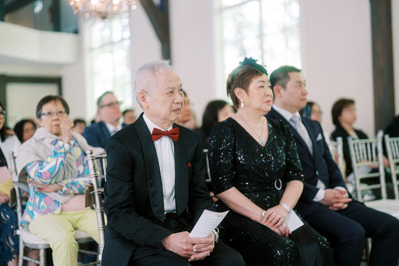 Well-dressed guests seated in rows during Miffy and Rawle’s indoor wedding ceremony at Ancaster Mill.