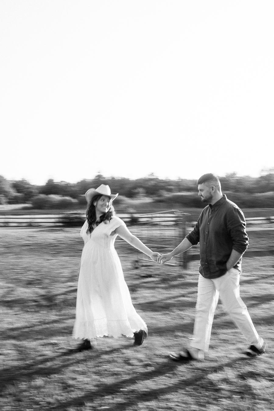 Expectant couple holding hands while walking at The Green Acres in Flamborough