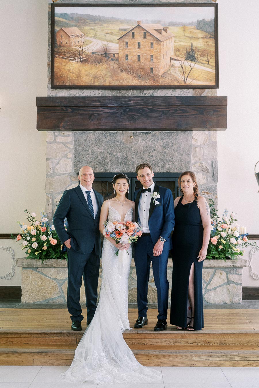Miffy and Rawle posing with two family members before a stone fireplace at Ancaster Mill