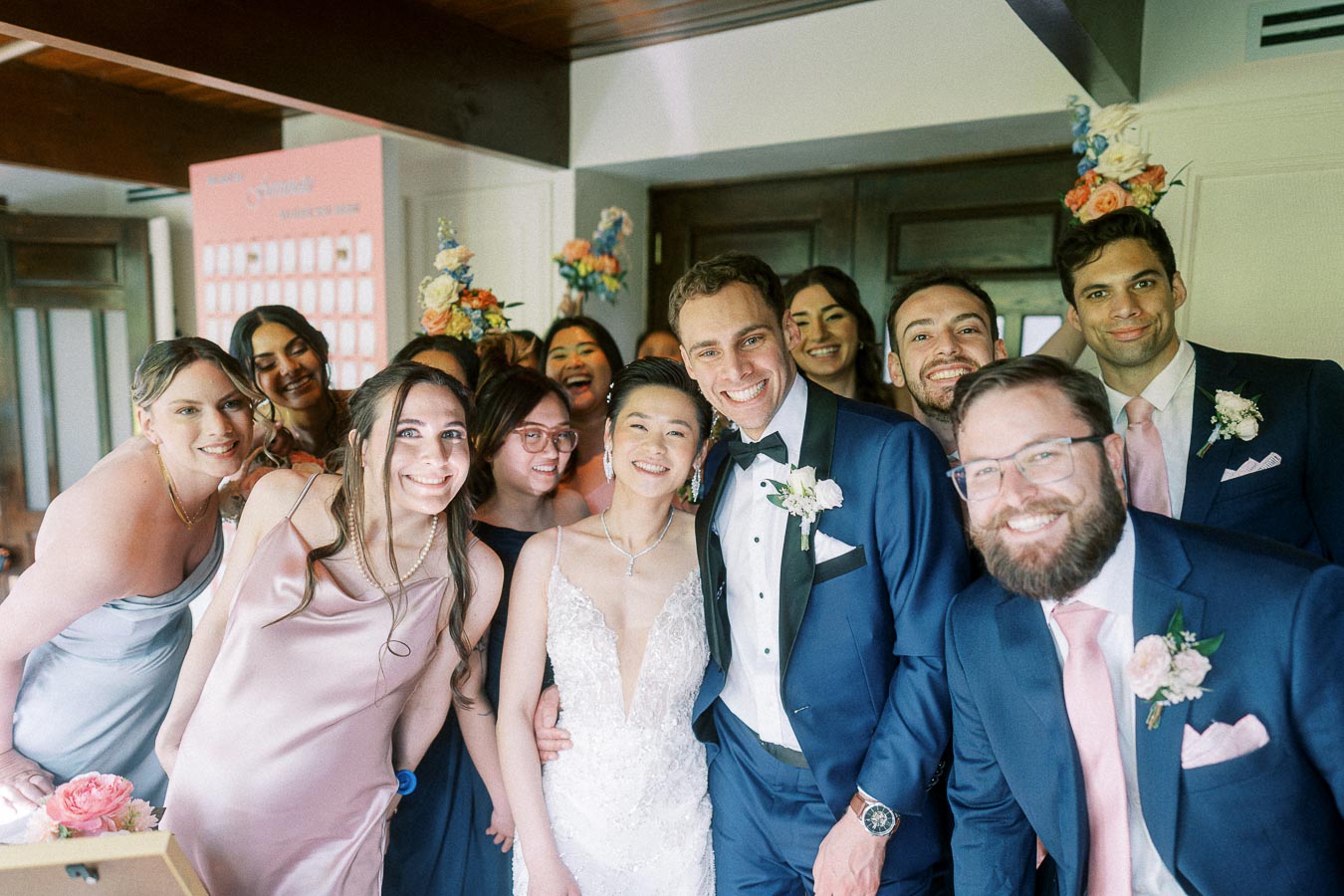 Miffy and Rawle smile with friends in formal wedding attire during their Ancaster Mill reception