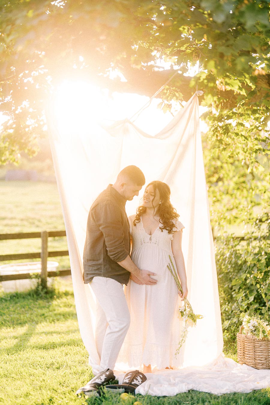 Expectant couple under trees during a maternity session at The Green Acres