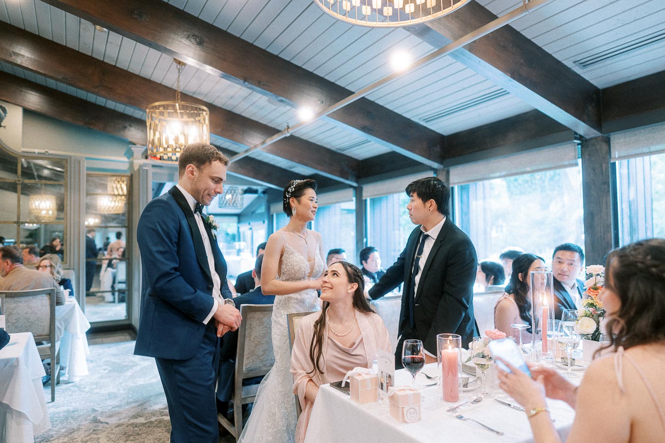 Bride and groom greeting seated guests at a candlelit Ancaster Mill wedding reception table