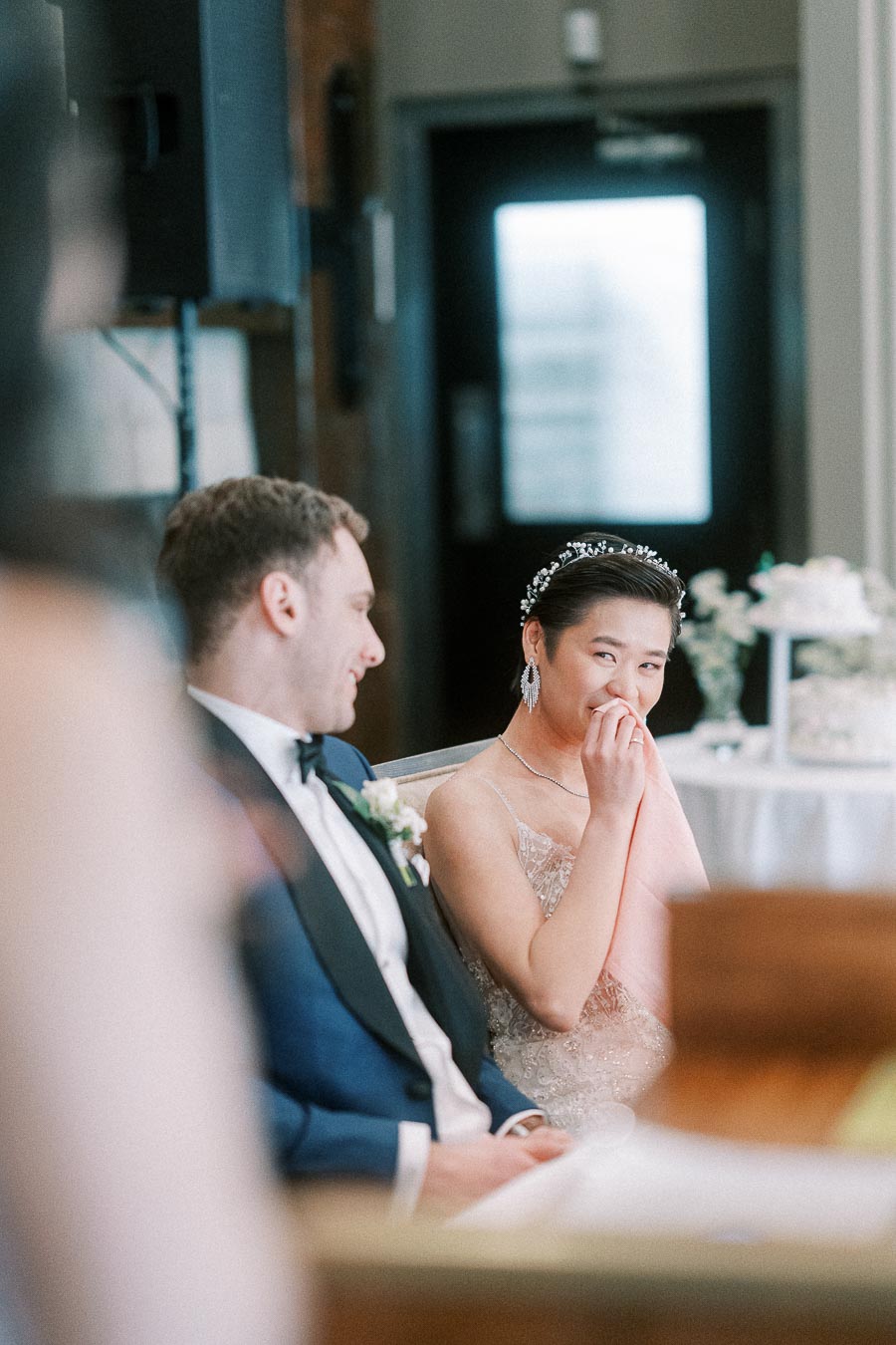 Bride wipes away tears while seated beside the groom during their wedding reception at Ancaster Mill.