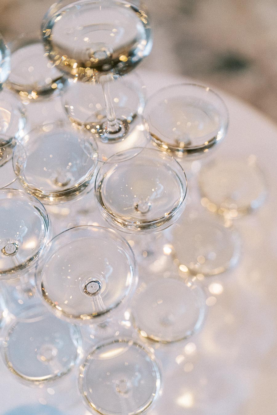 Stacked champagne glasses creating a cascading tower effect, reflecting light beautifully, ideal for weddings or celebrations.