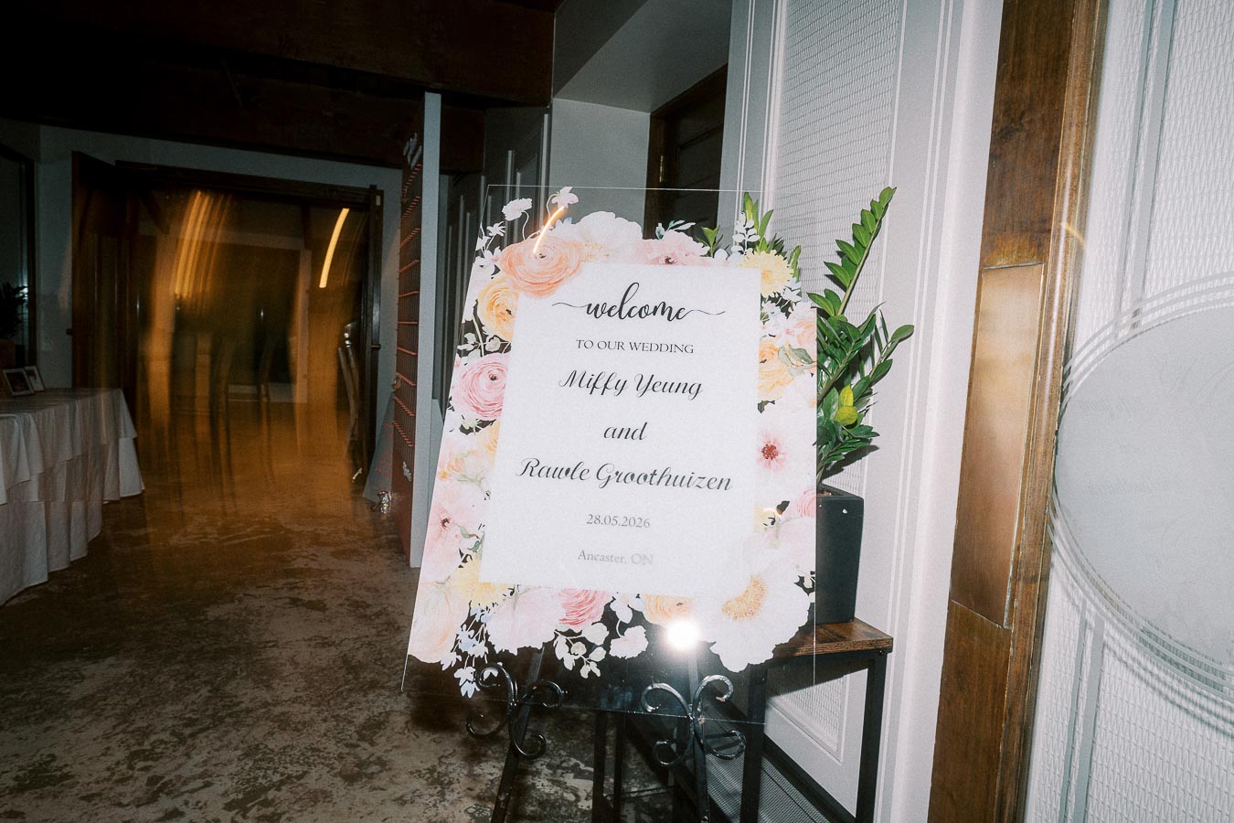 Wedding welcome sign with floral design at entrance, displaying festive decor and warm ambiance, perfect for an elegant ceremony celebration.