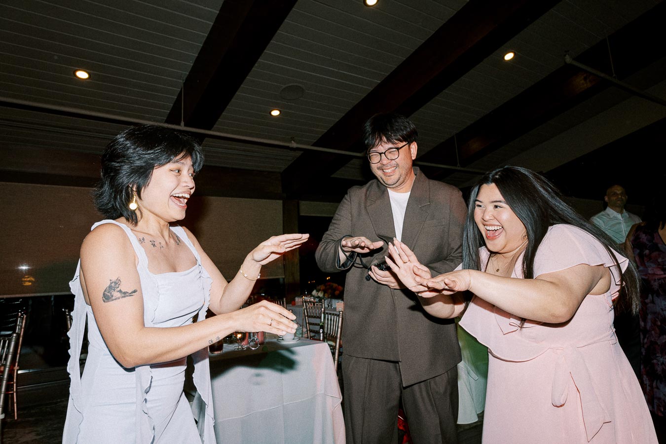 Group of people joyfully dancing at an indoor gathering, expressing happiness and camaraderie.