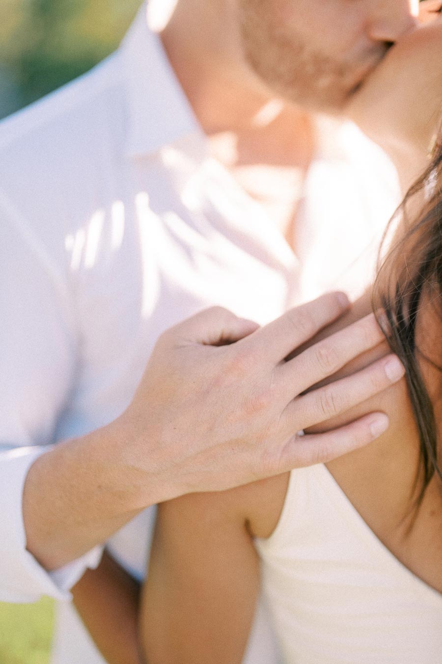 Matt kisses Rachel's shoulder while resting his hand on her during their engagement session.