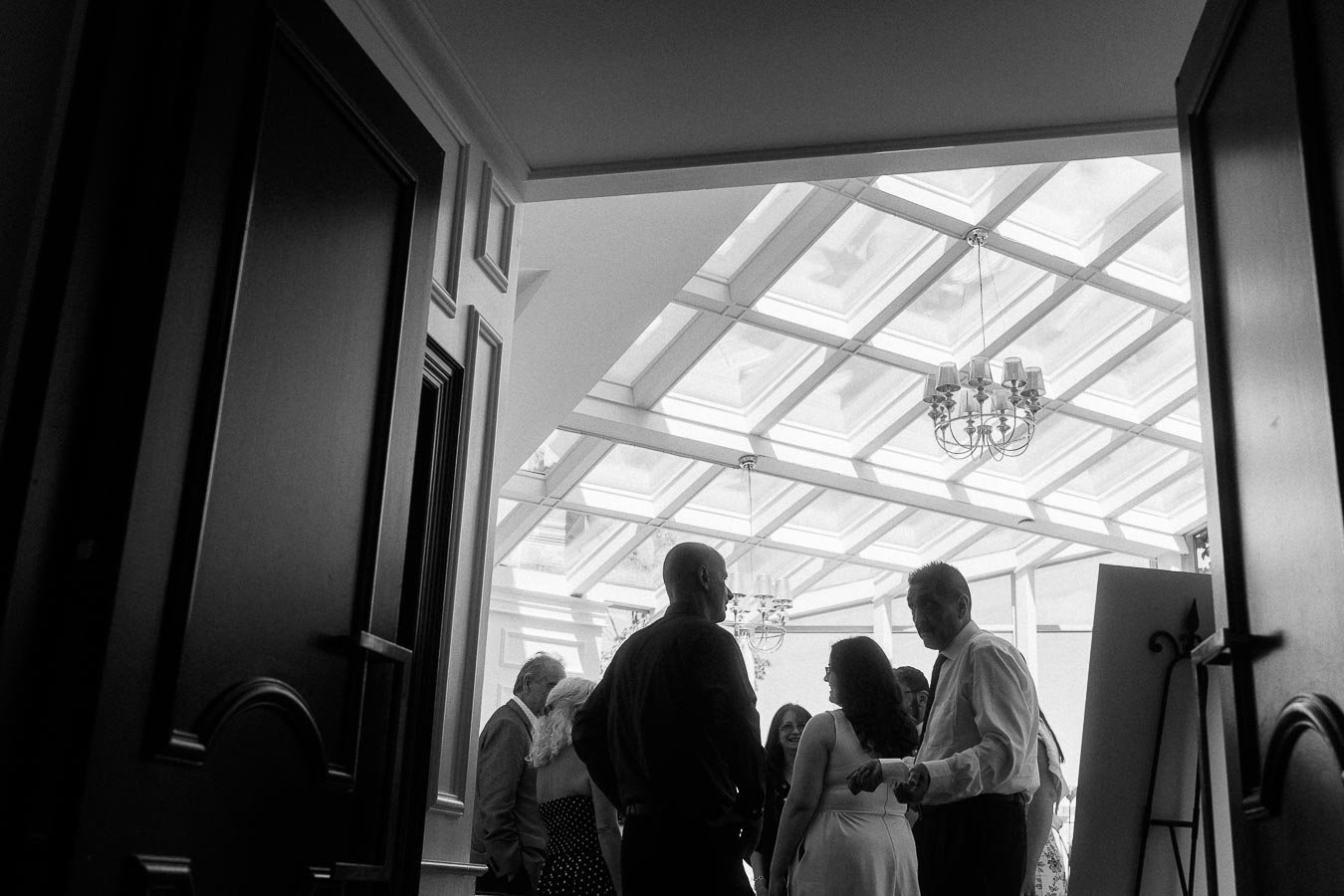 Guests mingling beneath a glass ceiling inside an event space