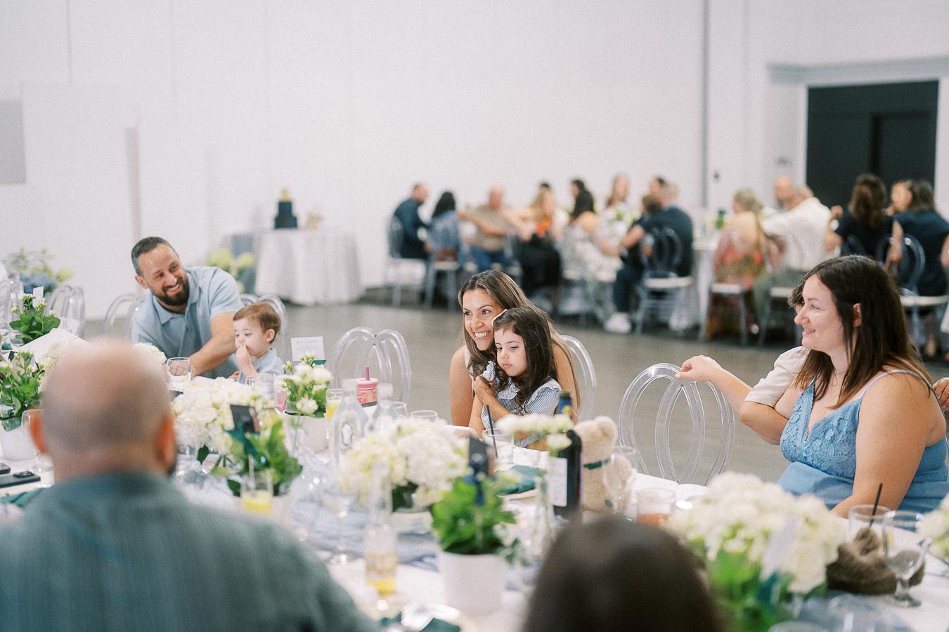 Guests seated around floral tables during a family celebration