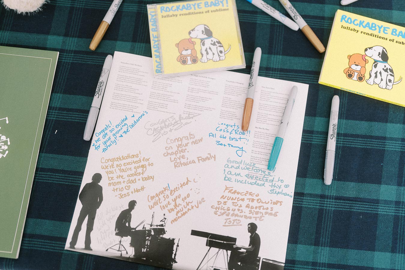 Guestbook page with handwritten baby shower messages and Sharpie markers on plaid fabric