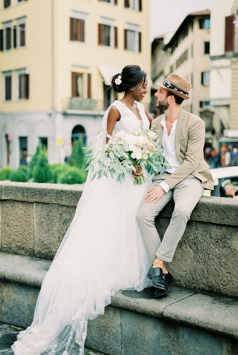 Wedding photography portrait of a bride and groom with a bouquet in a historic European city setting