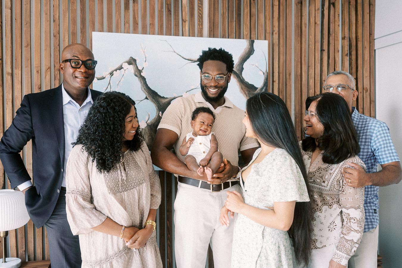Parents and family members smiling around newborn Isabella inside a Toronto home.
