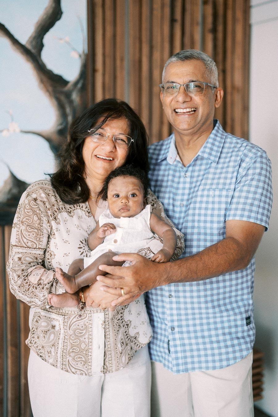 Two smiling family members hold newborn Isabella in a bright Toronto home.