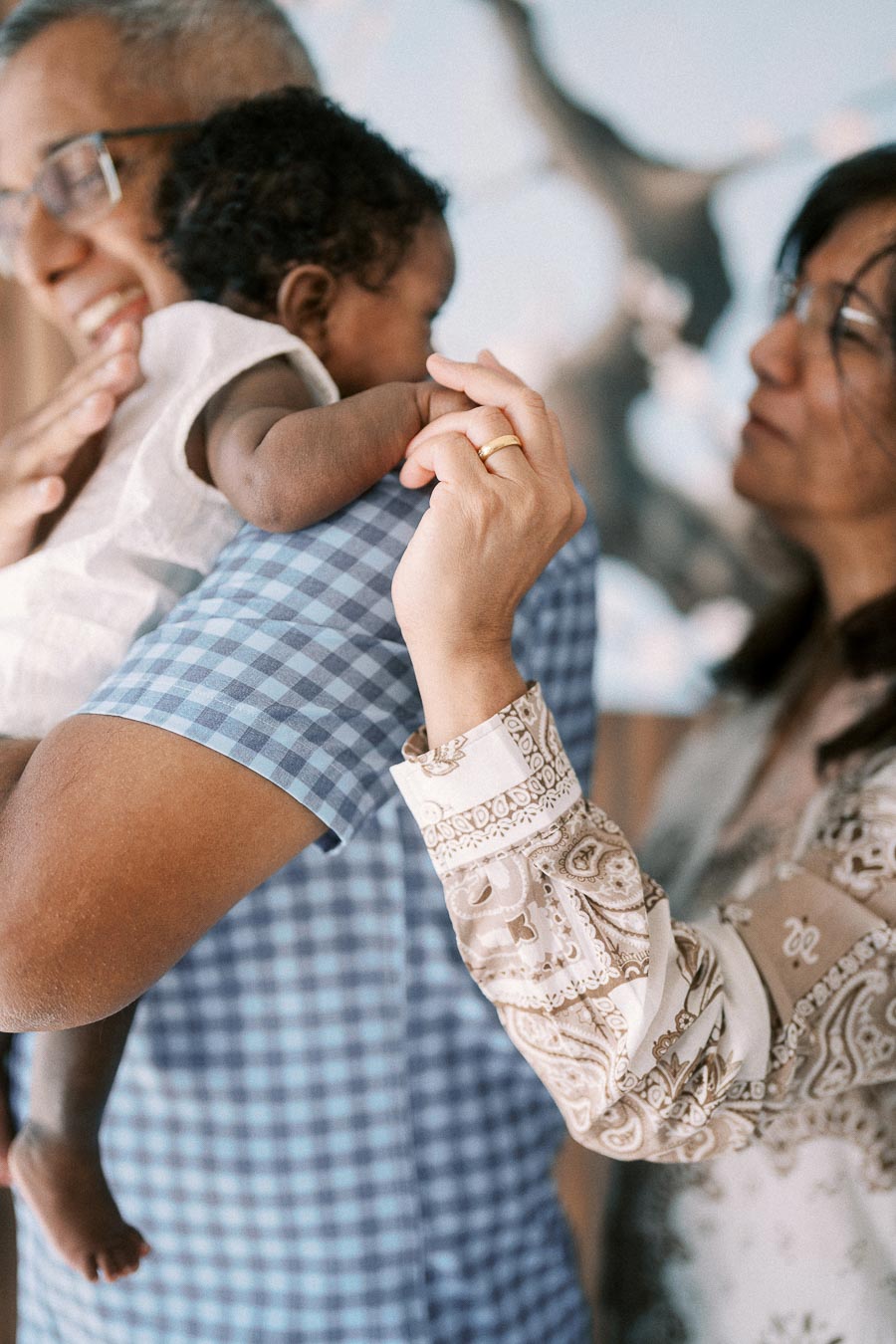 Family members gently holding newborn Isabella during an in-home Toronto newborn session.