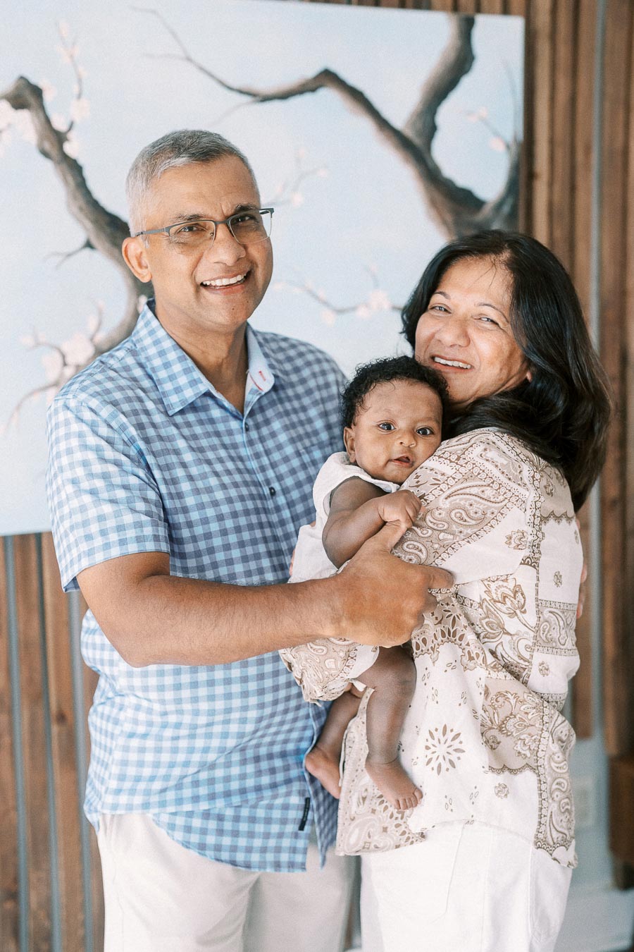 Smiling family members hold newborn Isabella in a bright Toronto home.