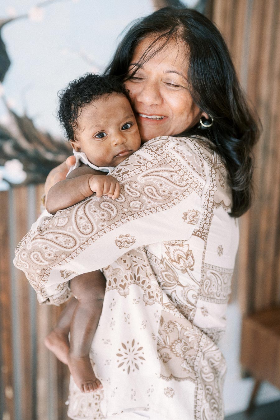 Family member cuddles baby Isabella against her shoulder in a Toronto home.