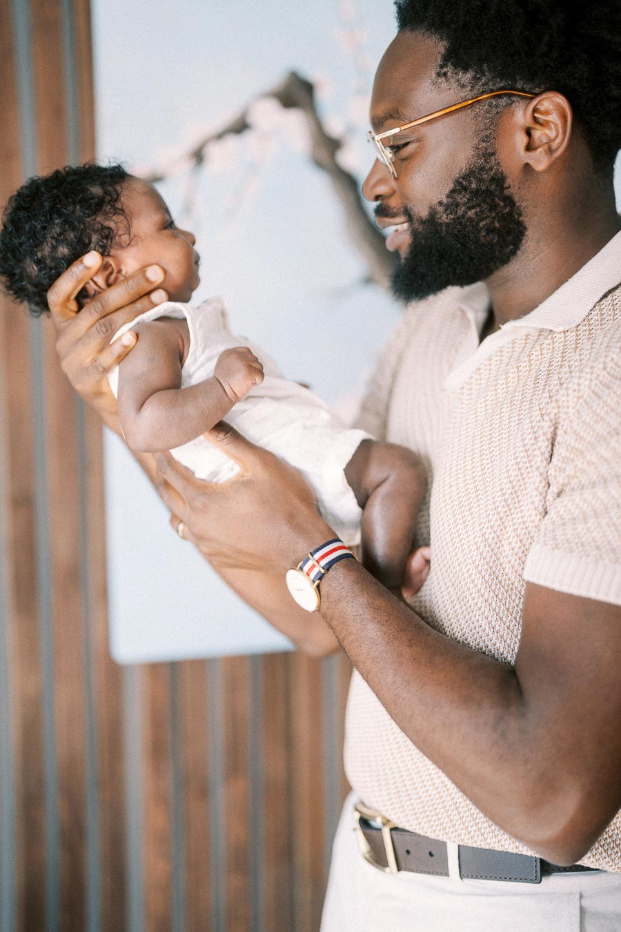 Terence gently holds newborn Isabella as they look at each other at home.