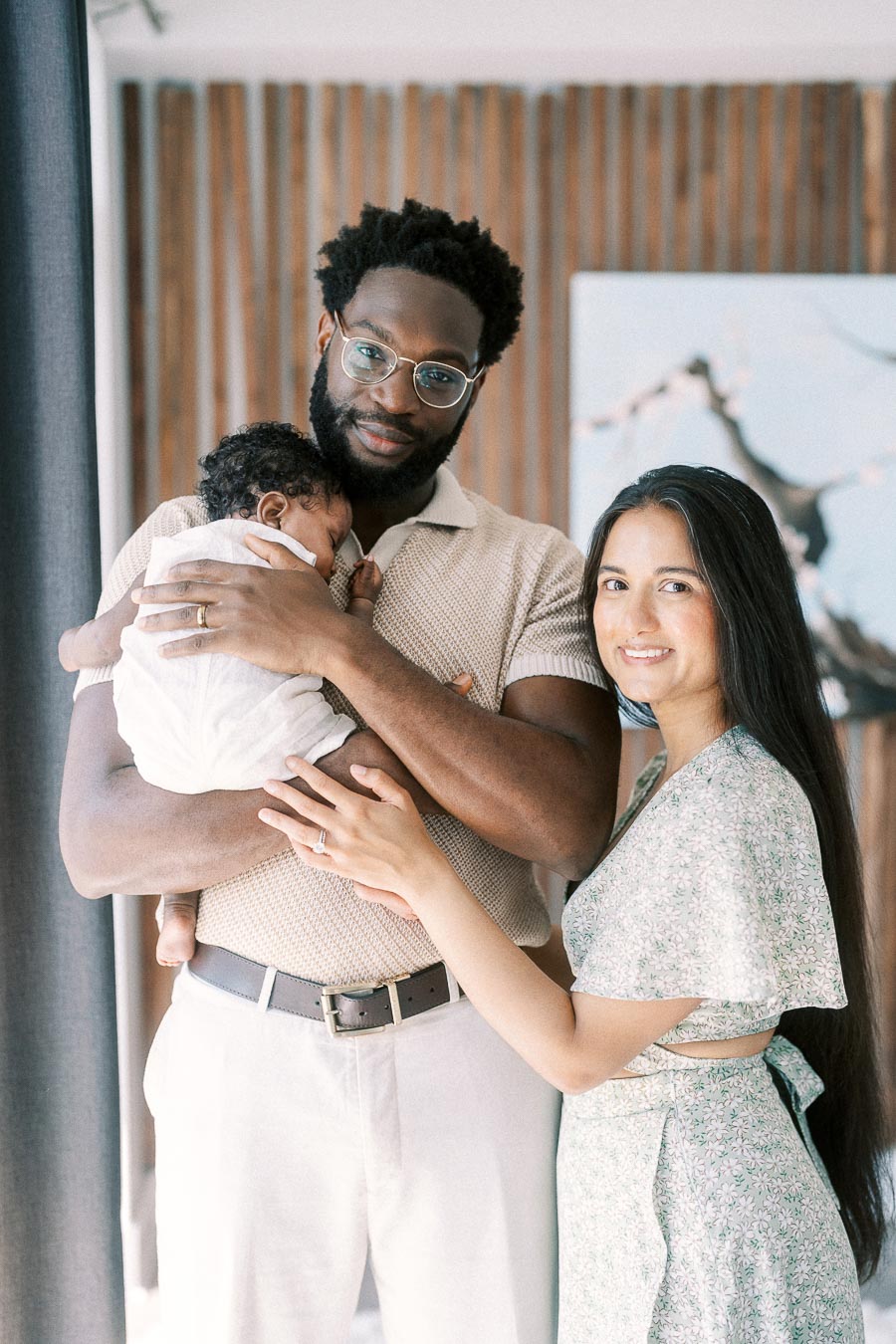 Terence holds newborn Isabella as Karina stands beside them in their Toronto home.