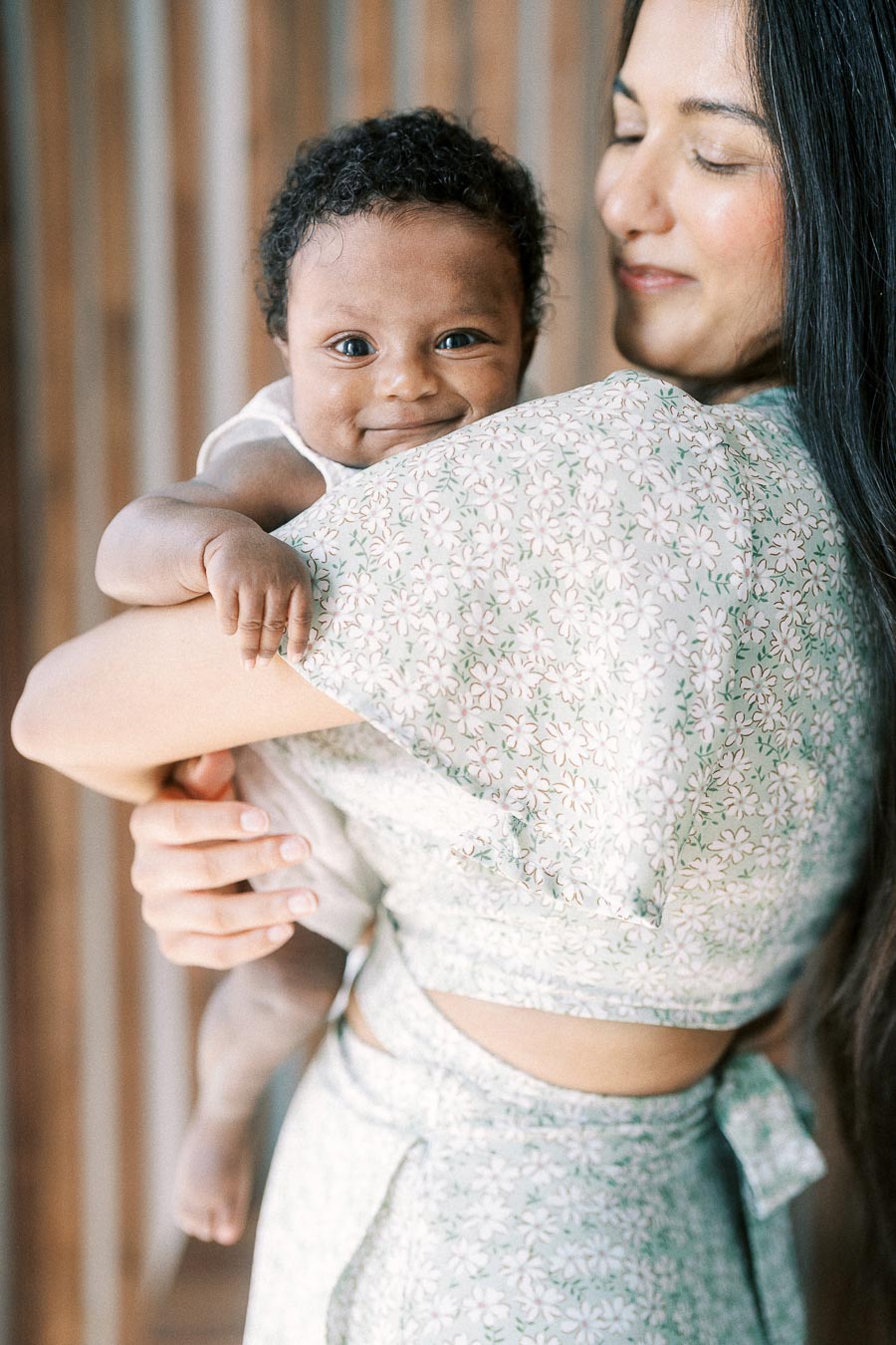 Karina holds smiling baby Isabella over her shoulder at their Toronto home.
